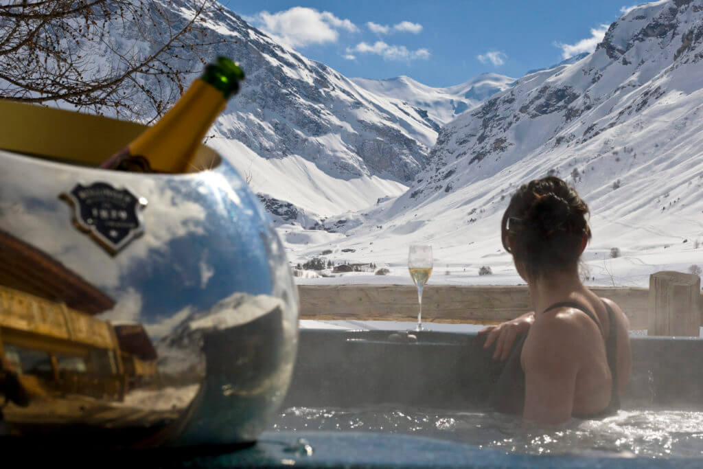 Alpine wedding guest enjoying the mountain views from the outdoor hot tub at Le Chardon Val d'Isere